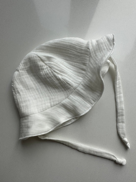 *PRE-ORDER* Двулицева бебешка шапка с връзки от муселин SS26