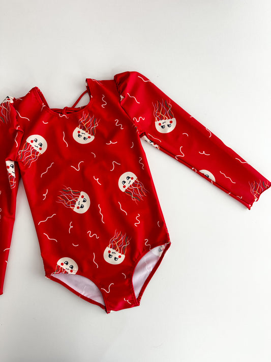 *PRECOMANDĂ* MARINA - Costum de baie pentru copii, dintr-o singură piesă, cu mâneci lungi și protecție UV (UPF 50+) - JELLY FISH RED HIGH VISIBILITY SS26